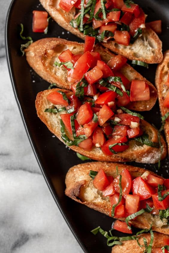 Bruschetta mit gewürfelten Tomaten und Basilikum auf geröstetem Brot